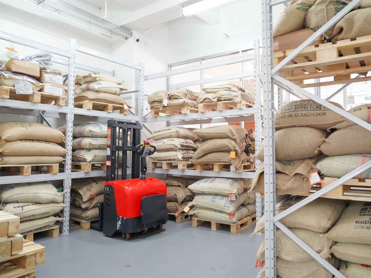 Burlap sacks of green coffee beans stacked in Morse Coffee's climate-controlled Futian warehouse.